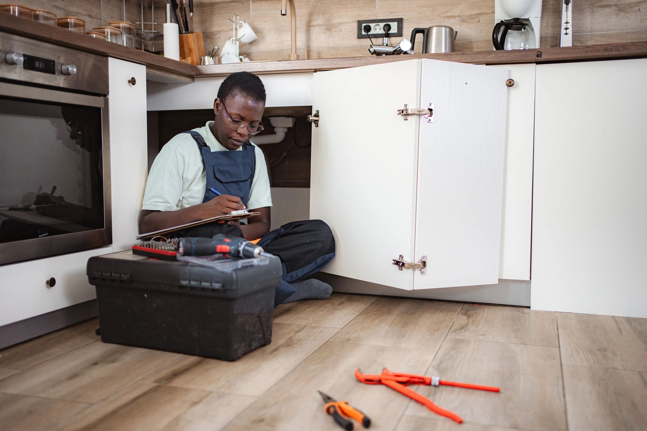 Plumber inspecting pipes in a client's home